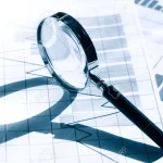 18998487-business-concept-magnifying-glass-on-paper-background-with-chart